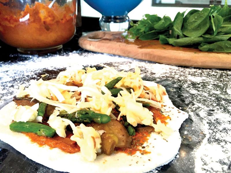 my familys favourite pizza asparagus and aubergine topped with smoked provoione cheese finished with fresh spinach and basil